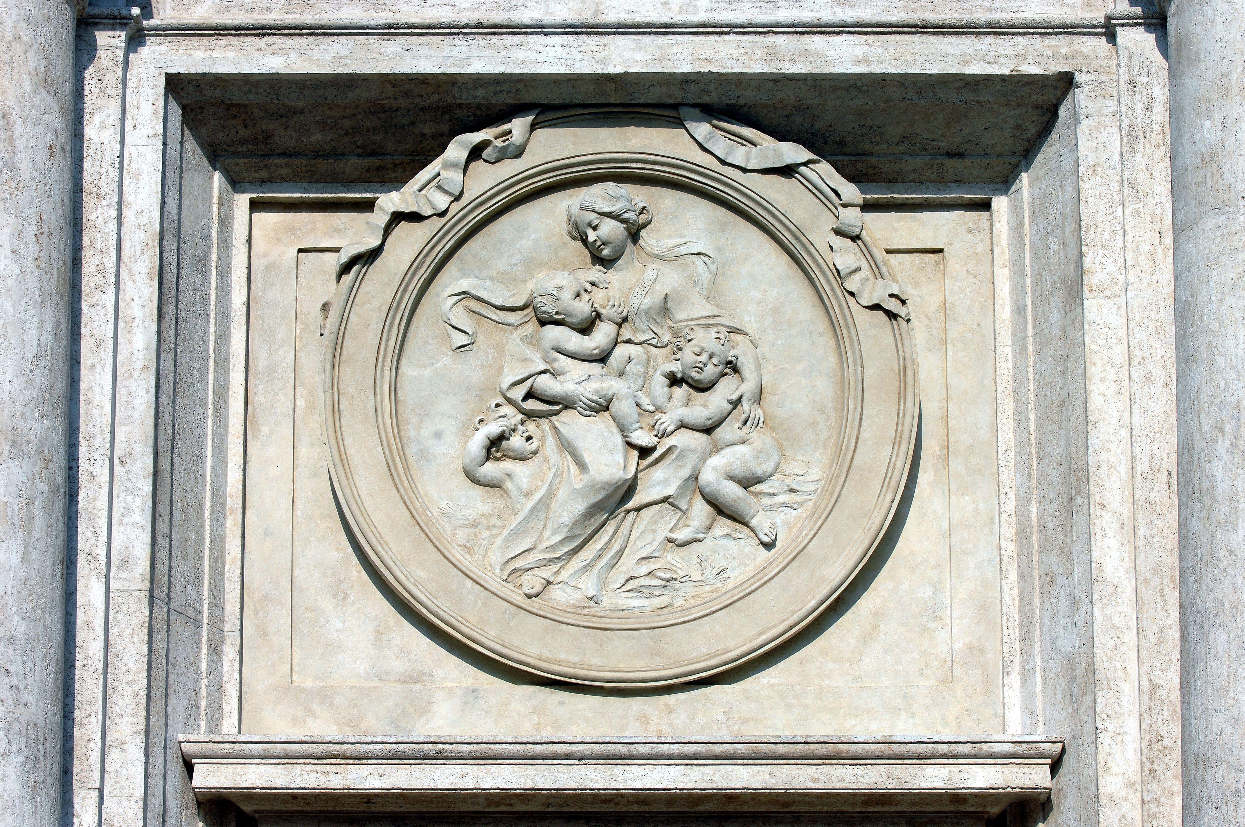 Palazzo Montecitorio, particolare del portone laterale dell'ingresso principale - La carità, tondo in bassorilievo