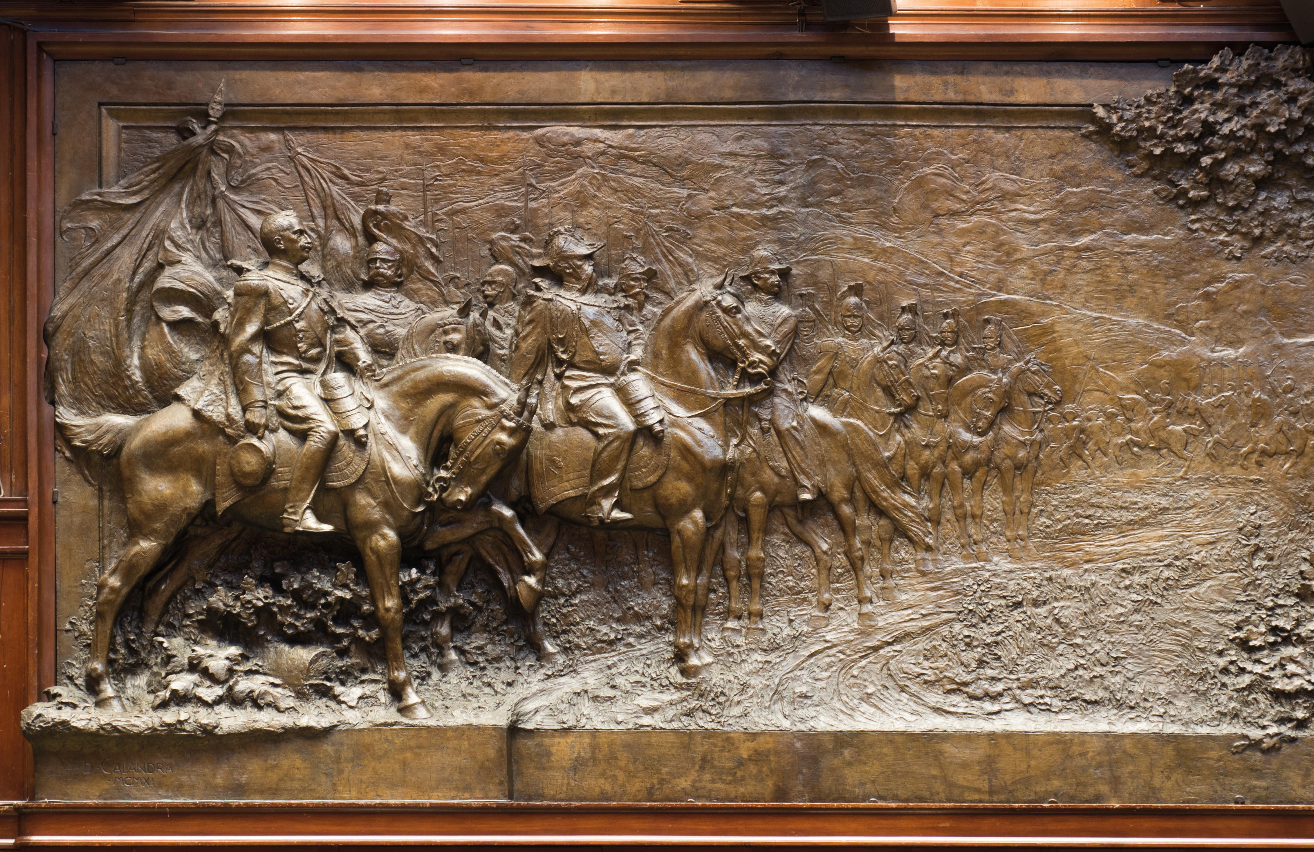 Il lato sinistro del pannello bronzeo raffigurante gli ultimi regnanti della famiglia Savoia (in primo piano Vittorio Emanuele III)
