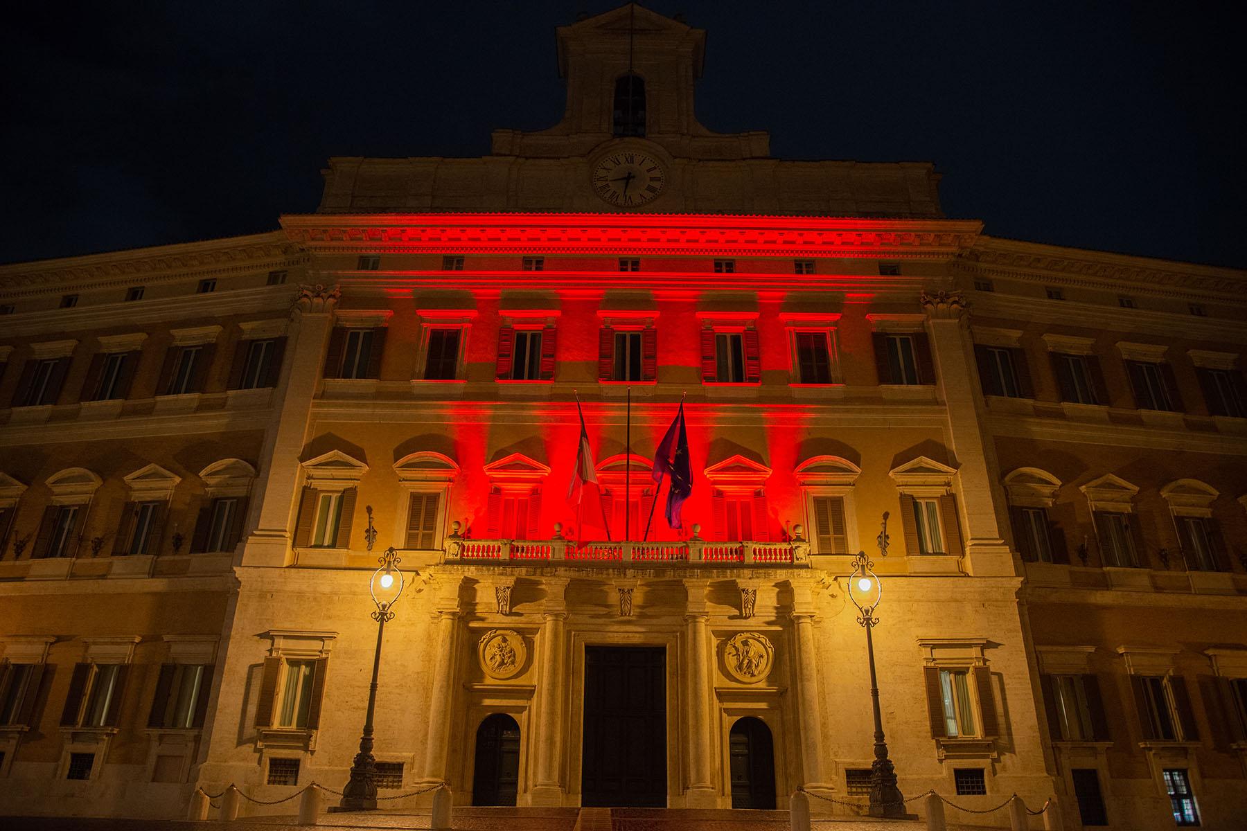 La facciata di Montecitorio illuminata di rosso